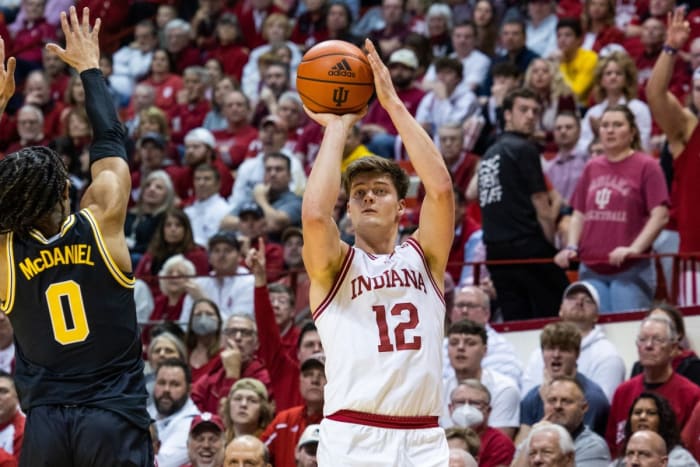 Miller Kopp (12) shoots the ball while Michigan Wolverines guard Dug McDaniel (0) defends.
